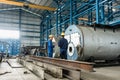 Experienced worker checking the quality of manufactured boilers Royalty Free Stock Photo