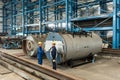 Experienced worker checking the quality of manufactured boilers Royalty Free Stock Photo