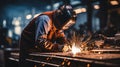 Experienced worker wearing protective gear while performing arc welding with an electric welder