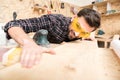 Experienced young woodworker is touching wooden board