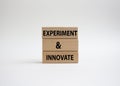 Experiment and innovate symbol. Concept words Experiment and innovate on wooden blocks. Beautiful white background. Business and Royalty Free Stock Photo