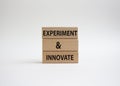 Experiment and innovate symbol. Concept words Experiment and innovate on wooden blocks. Beautiful white background. Business and