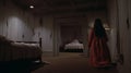 Experimental Cinematography A Woman In A Red Dress At The Edge Of A Dark Brown Bedroom