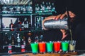 Expert barman is making cocktail at night club or bar. Glass of fiery cocktail on the bar counter against the background Royalty Free Stock Photo