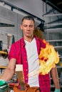 Expert carpenter burning a wood leg with a professional gas burner. Flames and smoke, fire and timber. Portrait of Royalty Free Stock Photo
