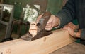 Expert carpenter handles boards a plane