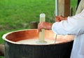 expert cheesemaker pour the rennet into the cauldron to produce