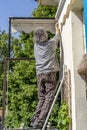 Expert craftsman is repairing a balcony awning