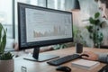 An expert is deeply focused on analyzing complex data displayed on a large monitor in a neatly organized workspace