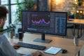 An expert is deeply focused on analyzing complex data on a large monitor, surrounded by a tidy desk featuring a notepad