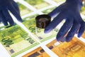Expert with gloves checks authenticity of euro banknotes