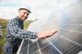 Expert is inspecting quality of a solar batterys. Worker in uniform and helmet with equipment. Ecology power