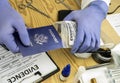 Expert police officer examining American passport of a evidence bag in laboratory of criminology