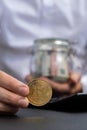 Expert trader hands showing Bitcoin coin digital gold after counting income banknotes of euro cash on calculator. Close