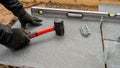 Expert Workman using a rubber mallet and spirit level tools to build a patio