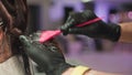 Close-up of hair colorist's hands transforming woman's hair with dye