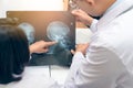 Expertise doctor planning treatment for medical concept. Two asian doctor looking at film x-ray head of patient and discussing