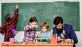 Explaining chemistry to kids. Fascinating chemistry lesson. Man bearded teacher and pupils with test tubes in classroom Royalty Free Stock Photo