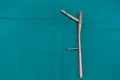 explanted femoral nail with locking screw lies on a green surgical drape