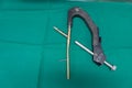 explanted femoral nail with locking screw lies on a green surgical drape