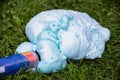 An exploded cylinder with construction foam on the grass. Balloon defect, close-up