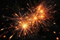 bright orange fireworks exploding in the night sky creating sparkling trails and glowing light effects against dark background Royalty Free Stock Photo