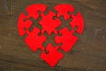 Exploding red heart puzzle on wooden table Royalty Free Stock Photo