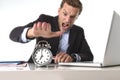 Exploited businessman at office desk stressed and frustrated with alarm clock in out of time and deadline concept Royalty Free Stock Photo