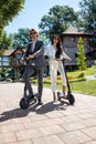 Exploiting the advantages of electric scooters, businessman and a businesswoman