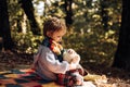 Explore nature together. Boy cute child play with teddy bear toy forest background. Picnic with teddy bear. Hiking with