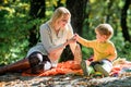 Explore nature together. Mom and kid boy relaxing while hiking in forest. Family picnic. Mother pretty woman and little