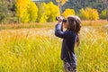 Explorer binocuar kid girl in yellow autumn nature