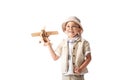 Explorer boy in glasses and hat holding wooden toy plane isolated on white