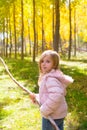 Explorer girl with stick in poplar yellow autumn forest