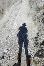 explorer with hat and his shadow on the stony path