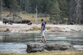 Explorer looking at bison while standing by lake in famous Yellowstone park Royalty Free Stock Photo