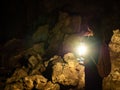 Explorer woman standing with an oil lamp Use bright lights to travel through very dark and natural stalagmite and rocky caves