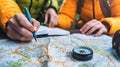 Explorers planning their adventure with map and compass in hand Royalty Free Stock Photo