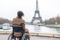 Exploring Paris as a wheelchair user. Back of disabled african american woman looking on Eiffel tower. Generative AI