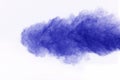 The explosion of blue colored powder. Freeze motion of color powder exploding on white background.