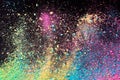 An explosion of colorful pigment powder on black background. Vibrant color dust particles textured background