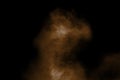 Explosion of deep brown powder on black background.Brown dust splash