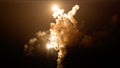 Explosion lighting up night sky with smoke column