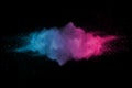 Explosion of multicolored dust on black background.