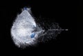 Explosion of a water filled balloon on a black background, shot through by a bullet, high speed photography, refreshing explosion