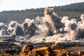 Explosive works on open pit coal mine industry with dust and puffs of smoke