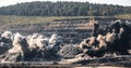 Explosive works on open pit coal mine industry with dust and puffs of smoke Royalty Free Stock Photo