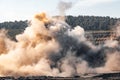 Explosive works on open pit coal mine industry. Dust and puffs of smoke in sky, blasted soil Royalty Free Stock Photo