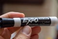 Expo Dry Erase marker, black, with hand holding for whiteboards. Mistakes, remove, education concepts Royalty Free Stock Photo