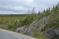 Exposed bedrock and dense forest landscape adjacent to Newfoundland highway Royalty Free Stock Photo